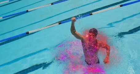 Male swimmer kicking upward in lane driving stroke causing pink particles swirling for sports win - Powered by Adobe