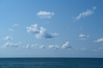 Blue sky with white clouds over the sea. Nature composition and background, copy space.