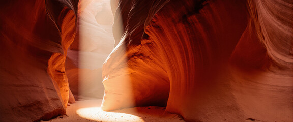 Red rock slot canyon features narrow undulating walls. Magical exit light creates sense of wonder and natural beauty.