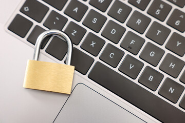 Cyber safety. Metal padlock on laptop, top view