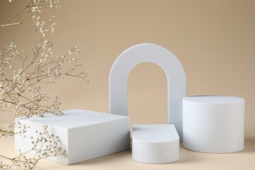 Promotion. Podiums for product presentation and gypsophila flowers on beige background, closeup