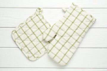 Oven glove and potholder on white wooden table, flat lay