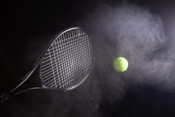 tennis racket and ball with smoke isolated on a black background.