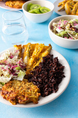 A balanced and nutritious breakfast with brown rice, baked white fish, fresh zucchini-carrot pancakes, a Chinese cabbage salad, and a sweet kiwi dessert, providing a perfect energy boost