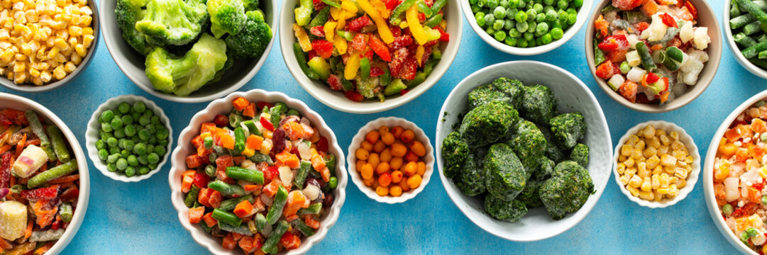 Freshly frozen vegetables in vibrant colors, neatly organized on plates with a soft blue backdrop, offering a glimpse into winter food preparation and storage, banner