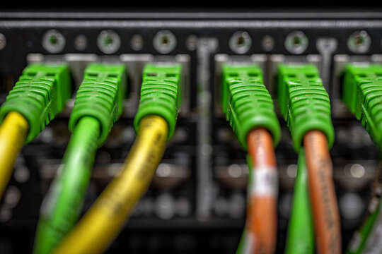 A bunch of green and yellow cables are connected to a black box - Powered by Adobe