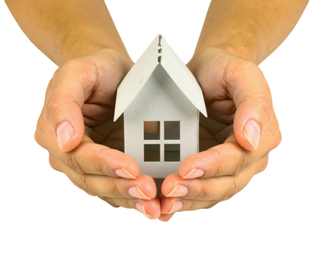A pair of hands gently holding a small white paper house model.