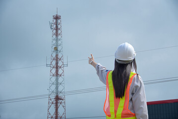 Female communications engineer wearing a helmet working outdoors
