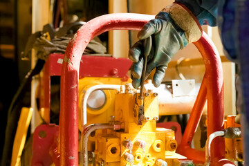 worker in rubber gloves holds a lever with his hand. Petroleum Equipment
