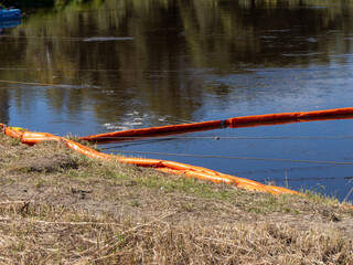 Environmental boom on riverbank. © Andrey