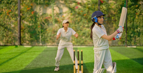 Indian gen z young adult sports woman lady wear hand gloves white dress leg guard helmet day time cricket player teen female girl hold bat play casual match game do batting at ground place