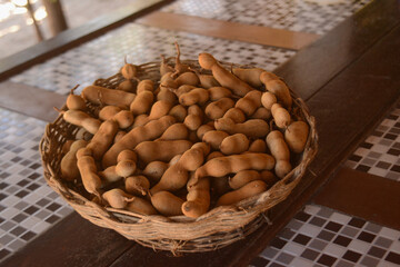 Cesto cheio de tamarindo em cima de uma mesa. Fruta Tamarindo  