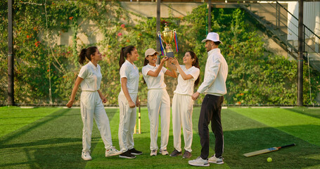 Indian asian young adult gen z sports woman lady group team standing with coach man win cricket match trophy do celebrate outdoor male trainer female player cheering having fun joy outside play ground