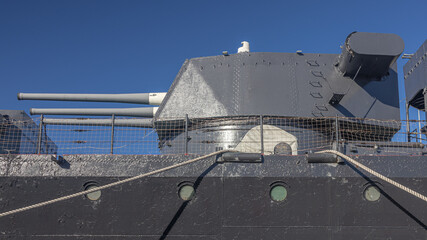 The deck of a battlecruiser with guns. A Soviet cruiser in the port. A warship with guns. Naval armament. The barrels of the cruiser's guns. The gun turret of a warship. © Eduard Belkin