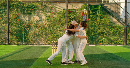 Indian young adult gen z sports woman lady group win match held award in hand raise up enjoy day time happy female team cheering have fun joy do hug at play ground place
