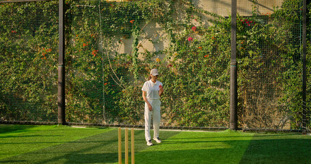 Indian young adult gen z bowler woman lady standing at match ground wear white uniform with cap. Asian teen age female girl running play cricket learn game do practice to hit wicket throw ball place