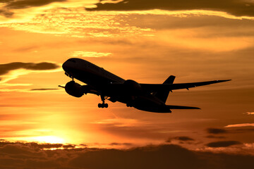 美しい空・雲を背景に飛ぶ航空機