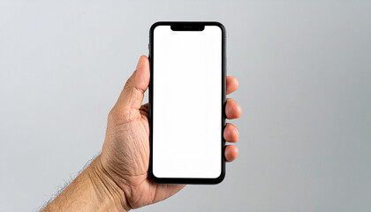 Hand holding a phone with a blank screen on a gray background