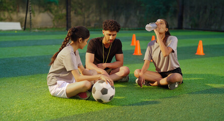 Indian young adult gen z woman lady talk casual gossip fit man coach guy take day time break area place male speak give game advice to teen sports female girl player hold bottle drink water	