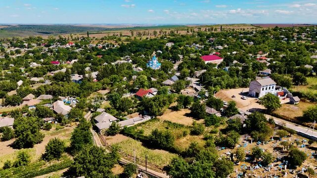 Aerial View of Moldovan Village with Blue and Gold Orthodox Church Surrounded by Lush Greenery