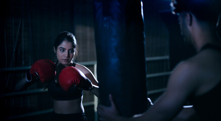 Indian young adult gen z angry fit boxer woman lady wear gloves do hand fist boxing punch beat on...