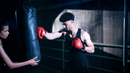 Indian young adult gen z angry fit boxer man guy wear gloves do hand fist boxing punch beat hit on...