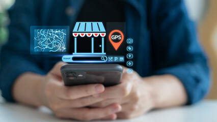 Hand holding a smartphone with hologram GPS navigation, map, and local business search icons. Concept of mobile map app, online store location, digital marketing, and smart navigation technology.