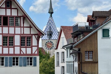 Obraz premium Zug, Switzerland - August 02, 2025: The Zytturm with its blue and white roof, the landmark of Zug's old town. A popular subject for tourists exploring the old town.