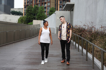 Asian Indian adult woman and Caucasian adult man urban rooftop outdoor casual pose walk talk activity friend colleague various expression