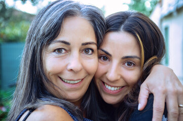 Happy mother and daughter embracing outdoors