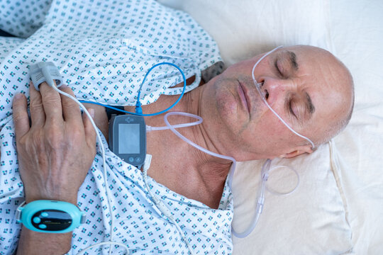 elderly man with sleep apnea monitoring device and fingertip pulse oximeter, senior male patient health tracker, adolescent sleep study equipment, breathing disorder research concept - Powered by Adobe