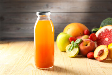 Tasty juice in glass bottle, fresh ingredients and basil on wooden table against brown background, closeup