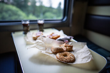 Pastries and tea arranged on dining table inside long distance train car. Freshly baked goods and hot beverages served during rail journey. Train food service, rail journey meal, onboard catering