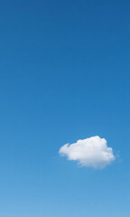 Single fluffy cloud floating in a vast expanse of bright blue sky, a simple, serene scene