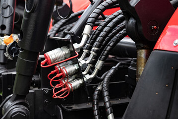 Close-up of hydraulic hoses and connectors on machinery equipment.