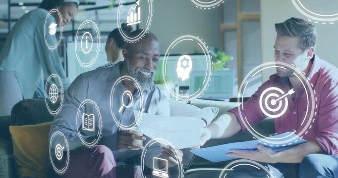 Business team exchanging printed pages on sofa while translucent data icons swirling