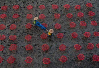 Two unidentified fishermen arranging fishnets. Close up, selective focus.