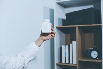 The pharmacist or doctor holding medication or medicine for treatment. Anti biotic pill in the vial.
