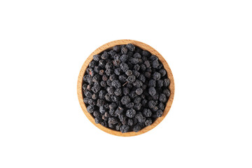 Dried Aronia or black chokeberry - Aronia melanocarpa in latin in wooden bowl isolated on white background.