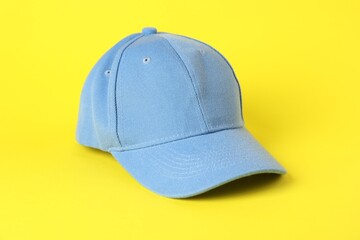 One light blue baseball cap on yellow background, closeup. Mockup for design