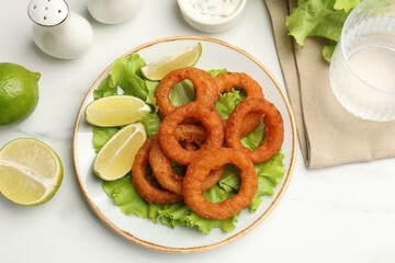 Fried squid rings served on white marble table, flat lay
