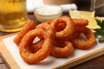 Fried squid rings served on wooden table, closeup