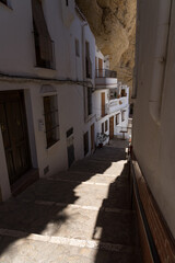 Herreria street in the beautiful white village of Setenil de las Bodegas in Cadiz, Spain, in a sunny day.