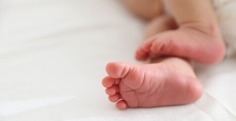 Cute newborn baby lying on bed indoors, closeup. Space for text