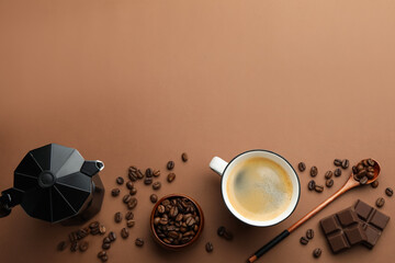 Aromatic coffee in cup, beans, moka pot and pieces of chocolate on brown background, flat lay. Space for text