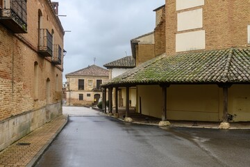 Portico with stone and wood columns of the Church of San Pedro in Cisneros, Palencia