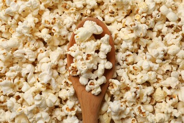 Tasty popcorn and spoon as background, closeup