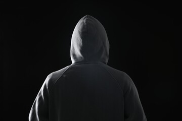 Criminal in hood on dark background, back view
