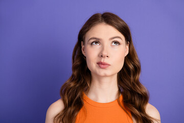 Fototapeta premium Beautiful and stylish with vibrant fashion posing against a purple background, wearing a vibrant orange top