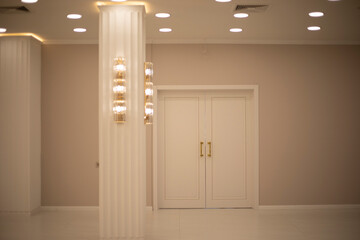 Doors in the interior. Warm light in the hall. Closed doors.